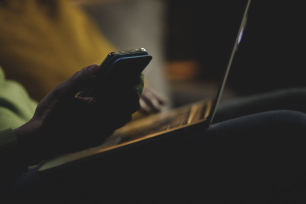 一个面目全非的人在用手机和笔记本电脑图片下载