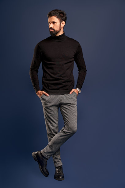 对自己完美的外表充满自信。全身自信的年轻英俊的男子手握在口袋里，看着一边，而站在太平洋蓝色的背景图片下载