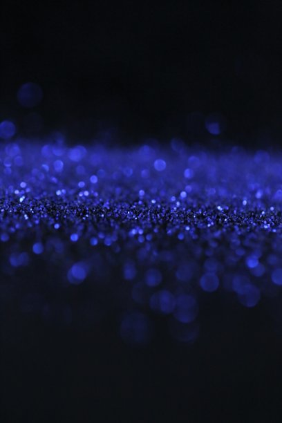 壁纸手机闪闪发光。灿烂光辉的表面。蓝色的闪光与闪光的散焦在黑色的背景。节日的背景。新年和圣诞节的背景。闪亮的纹理图片下载