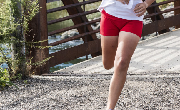 女跑步者的腿向左转跑过一座桥图片下载