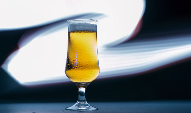 一杯淡啤酒在一个黑暗的背景，用光画线，一个复制空间横幅图片下载