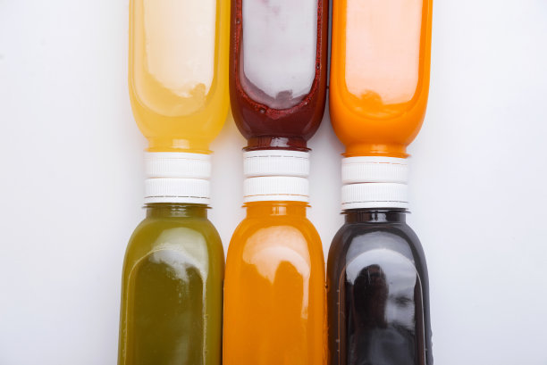 俯视图照片的新鲜排毒果汁瓶在白色的背景。健康的风格图片下载