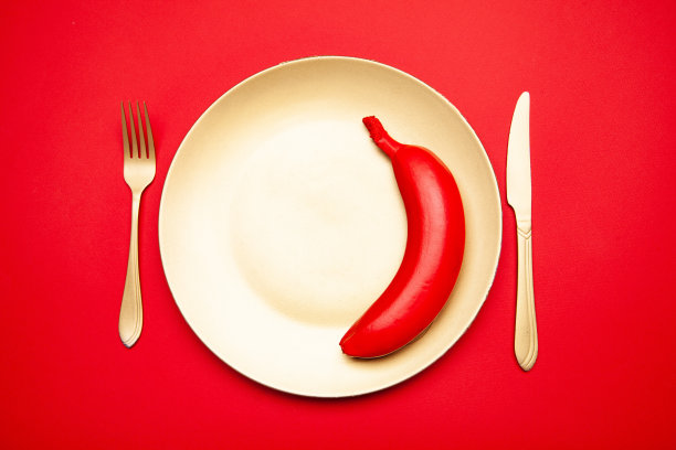 用刀叉把红香蕉放在盘子里图片下载