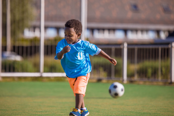 漂亮的年轻黑人男孩在足球场上训练图片下载
