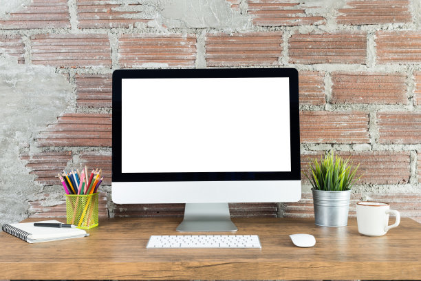 工作空间的电脑与空白的白色屏幕，办公用品在一个木制的桌子上图片下载