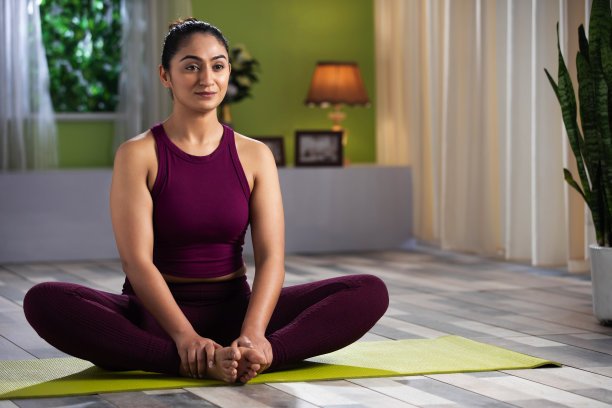 美丽迷人的年轻女人在家里做瑜伽锻炼，健康概念，健身概念，库存照片图片下载