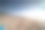 海景与模糊的人行走在背景。海滩上人们的剪影，浴巾的尖端在海滩上，聚焦前景图片下载