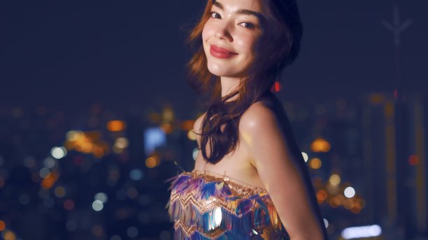 年轻的中国成年女性晚上在城市里拿着智能手机图片下载