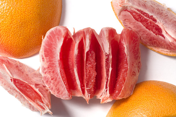 剥皮新鲜多汁的葡萄柚果肉和果皮孤立在白色背景俯视图图片下载