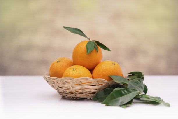 柳橙装在带叶子的柳条篮子里图片下载
