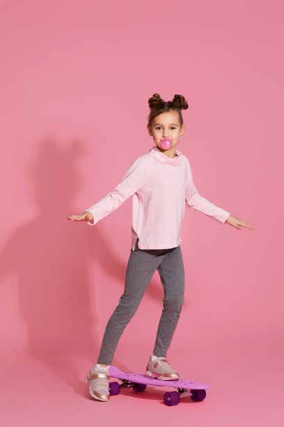 嚼着口香糖的小女孩拿着滑板图片下载