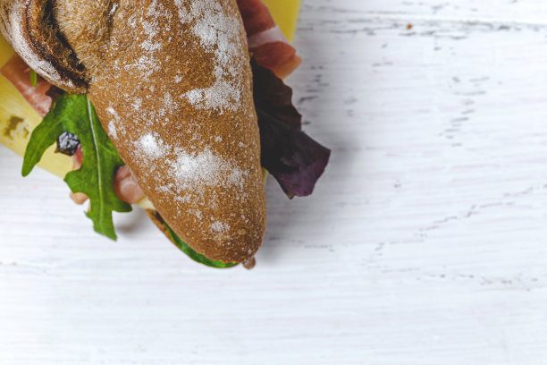 自制火腿三明治配芝麻菜，生菜和奶酪外卖。交付的食物图片下载