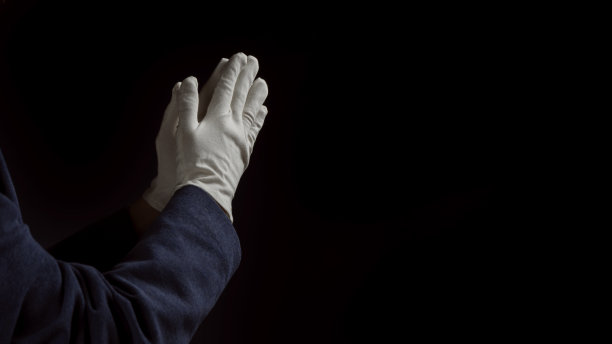黑色背景中的男子祈祷手。关闭了。图片下载