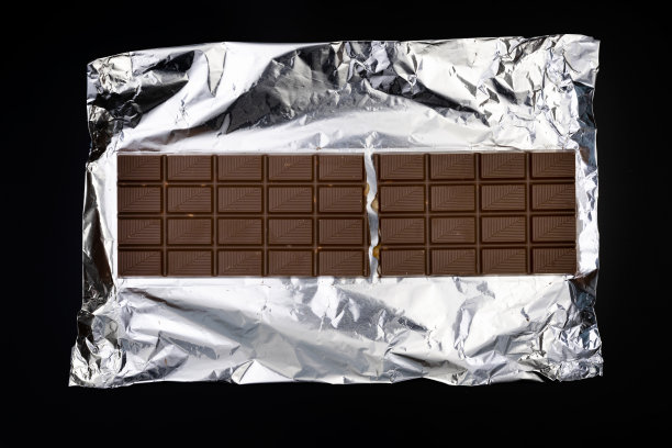 甜美美味的巧克力棒，银箔，黑色背景图片下载