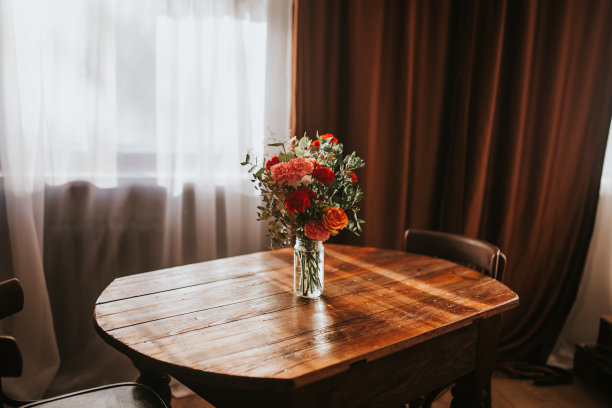 浅色背景前的木桌上放着一个插着花的玻璃花瓶。浪漫的情人节心情。妇女节，礼物三月八号图片下载