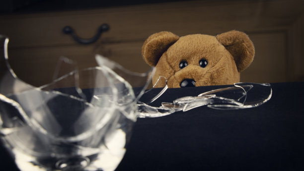 泰迪熊和破碎的酒杯。酗酒、暴力、离婚和破碎的家庭观念。图片下载