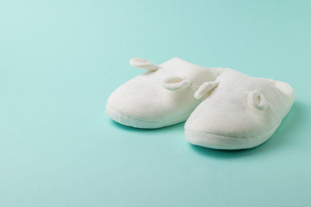 温暖的拖鞋与耳朵在浅蓝色的背景。图片下载
