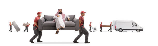 沙特阿拉伯男子喝着茶，坐在搬运工搬运的沙发上图片下载