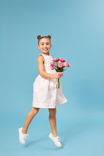 快乐的小女孩拿着一束玫瑰跳了起来图片下载