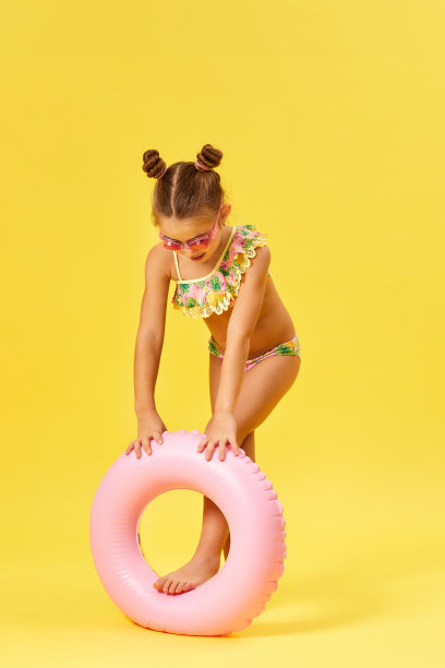 小女孩穿着泳衣，戴着充气橡胶圈图片下载