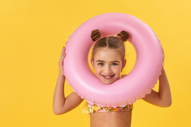 小女孩穿着泳衣，戴着充气橡胶圈图片下载