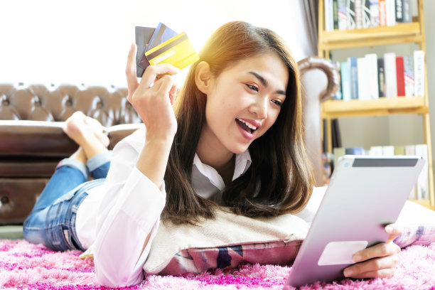 图片显示一个漂亮的女人用信用卡在网上购物，用数字平板电脑在网上购物图片下载