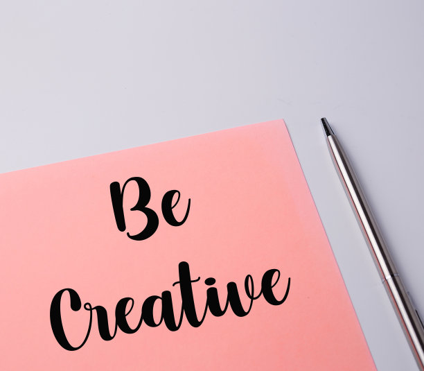 俯视图的粉红色的纸和一支笔与创造性的措辞。经营理念图片下载