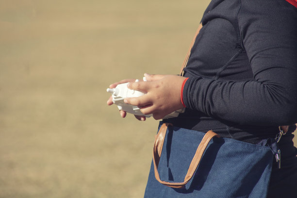 这个男孩拿着一个四旋翼飞行器遥控器图片下载