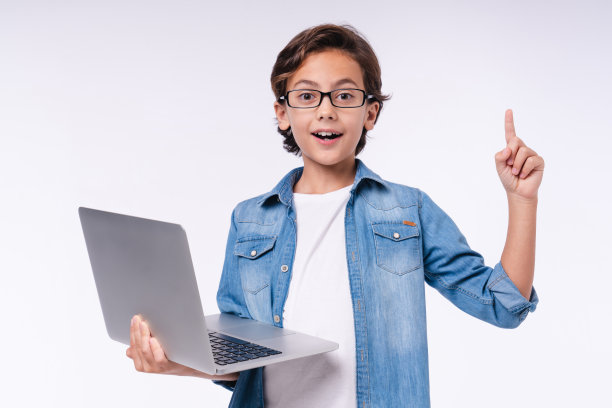 聪明的小男孩有想法的笔记本电脑孤立在白色的背景图片下载
