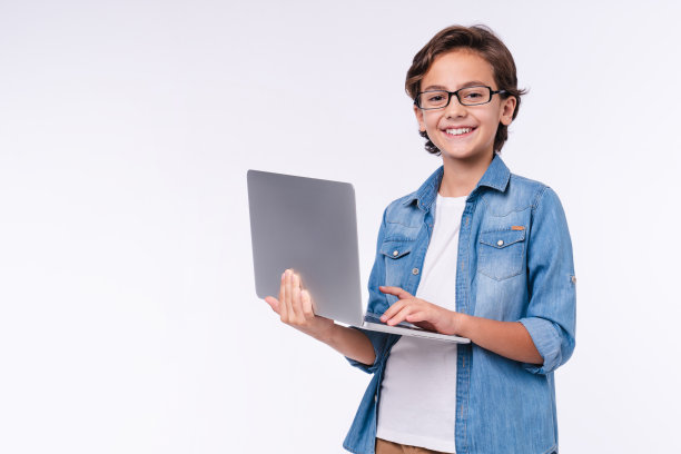 聪明的小男孩与笔记本电脑在休闲衣服孤立在白色的背景图片下载