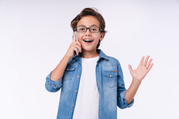 惊讶的小男孩打电话孤立在白色的背景图片下载