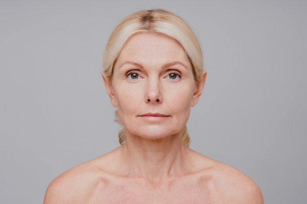 近距离肖像中年美丽的女人显示她的美丽孤立在灰色的背景图片下载