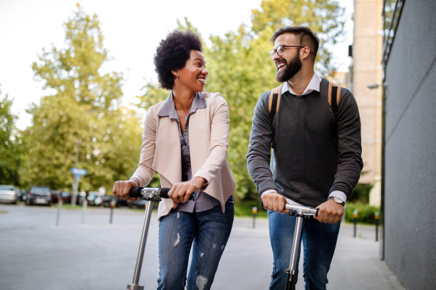 可爱的夫妇有乐趣驾驶电动车在城市户外图片下载