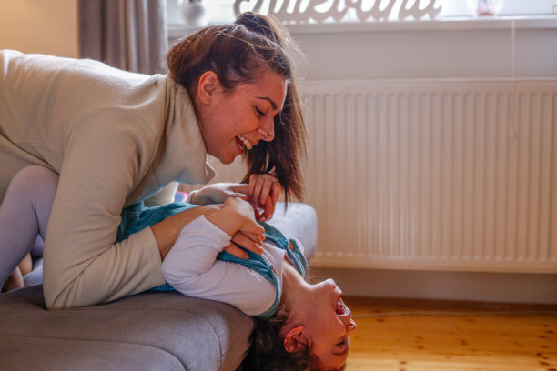 快乐的小女孩和她妈妈玩得很开心。库存图片图片下载