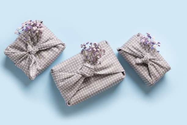 春天的环保礼物，灰色的纺织品包装，蓝色的花朵。“零浪费”。传统的日本Furoshiki风格。图片下载