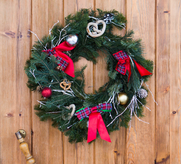 用杉木树枝做成的圣诞花环挂在木门上。图片下载