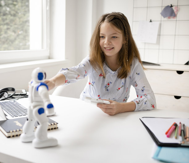 年轻的金发女学生正在玩她的机器人玩具图片下载