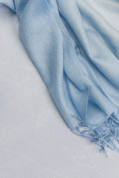 背景纺织品与针织围巾的纹理与流苏，蓝色织物的颜色梯度在柔和的阴影，衣服和配饰图片下载