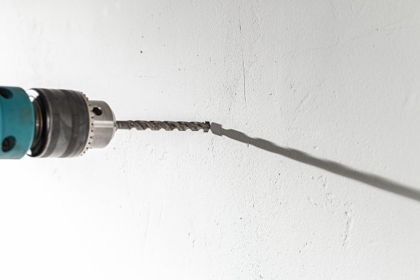 在混凝土墙上钻孔的特写图片下载