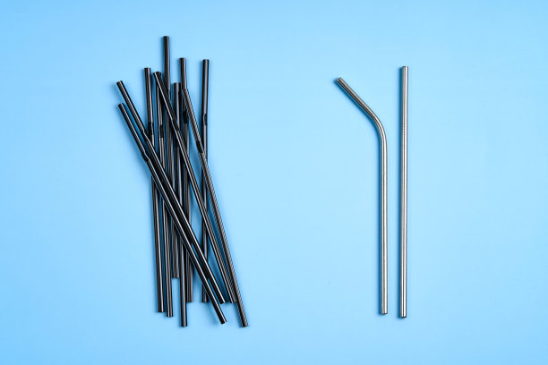 关心环境的现代趋势。一包黑色的塑料饮料吸管，而只有两根可重复使用的金属饮料吸管图片下载