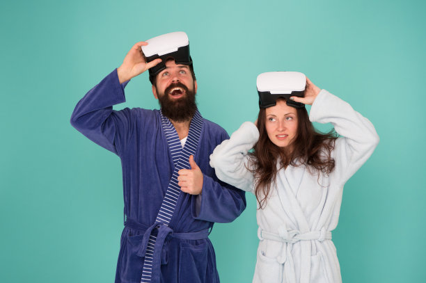 回到现实。男人和女人探索vr。VR技术与未来。虚拟现实的沟通。激动人心的印象。从虚拟现实中觉醒。情侣们穿着浴袍，戴着vr眼镜。意识的觉醒图片下载