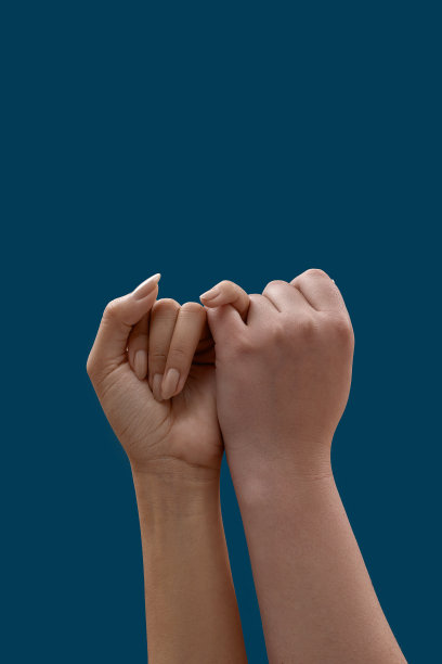 两只手互相勾着小指，小指作为承诺或赦免的象征孤立在蓝色的背景上图片下载