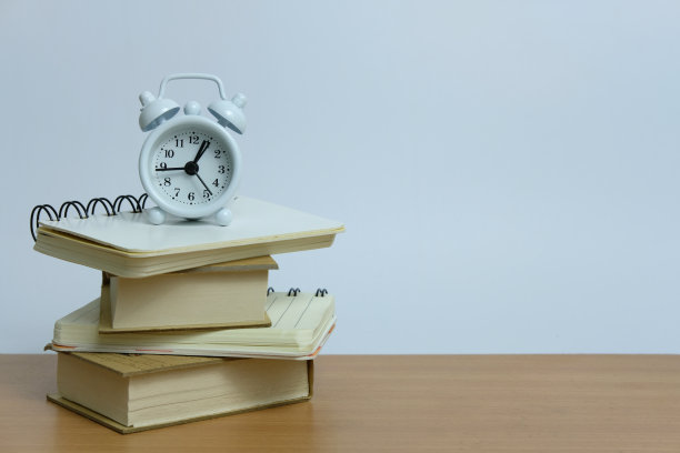办公室工作负荷的概念——一堆书，上面放一个钟。图片下载