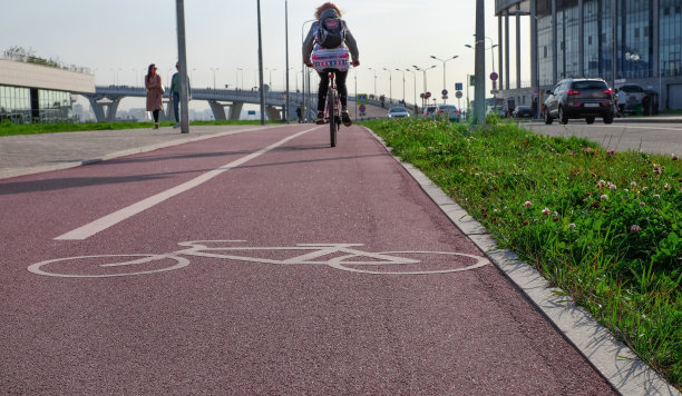 红色自行车道上的自行车标志和骑自行车的少女，城市景观，积极的生活方式图片下载