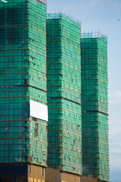 一幢正在施工的建筑周围有安全网。正在建造高楼。图片下载