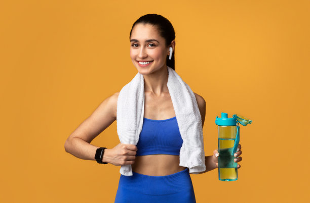 运动型女人在工作室拿着一瓶水图片下载