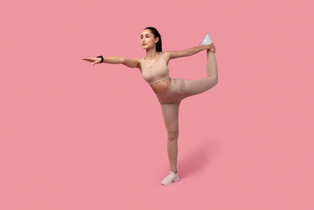 微笑的年轻女子做抬腿平衡运动图片下载