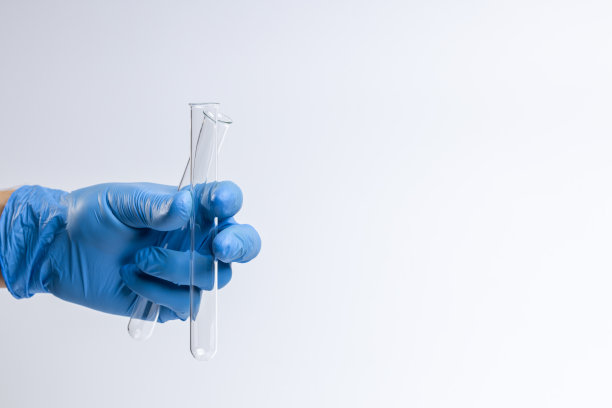 医护人员或科学家拿着玻璃试管隔离在灰色背景下。副本的空间。图片下载