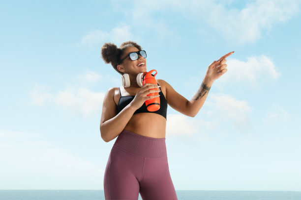 女性时装模特的肖像在蓝天的背景。风格美观，外观亮丽。生活方式的运动。图片下载