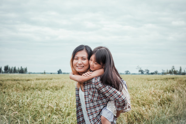 妈妈在公园里让女儿骑回来。幸福的肖像。可爱的女孩和妈妈在户外玩。图片下载